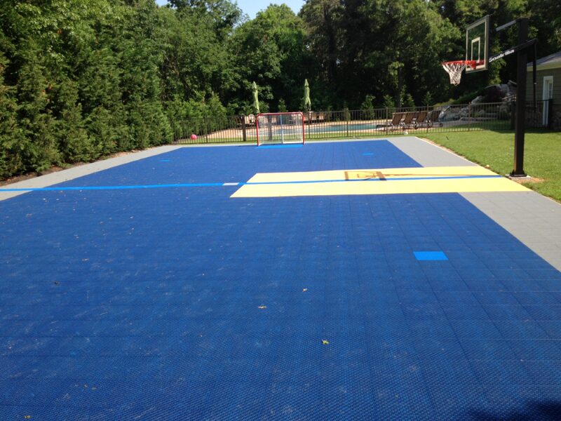A basketball court with blue and yellow tiles.