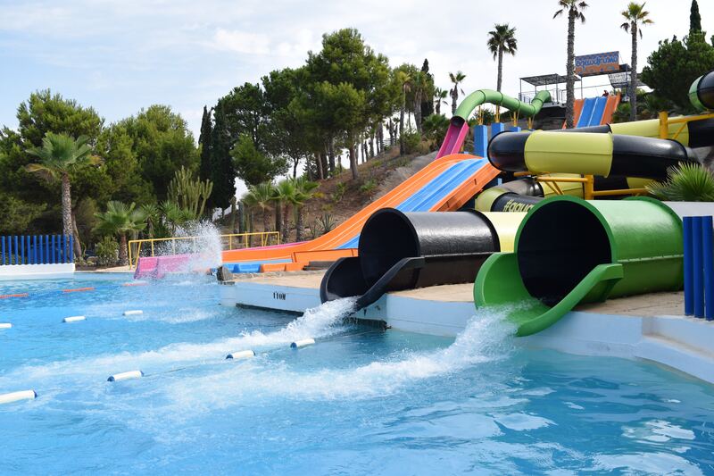 A water slide with many slides in the pool