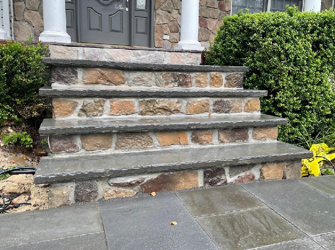 A stone staircase with steps leading to the front door.