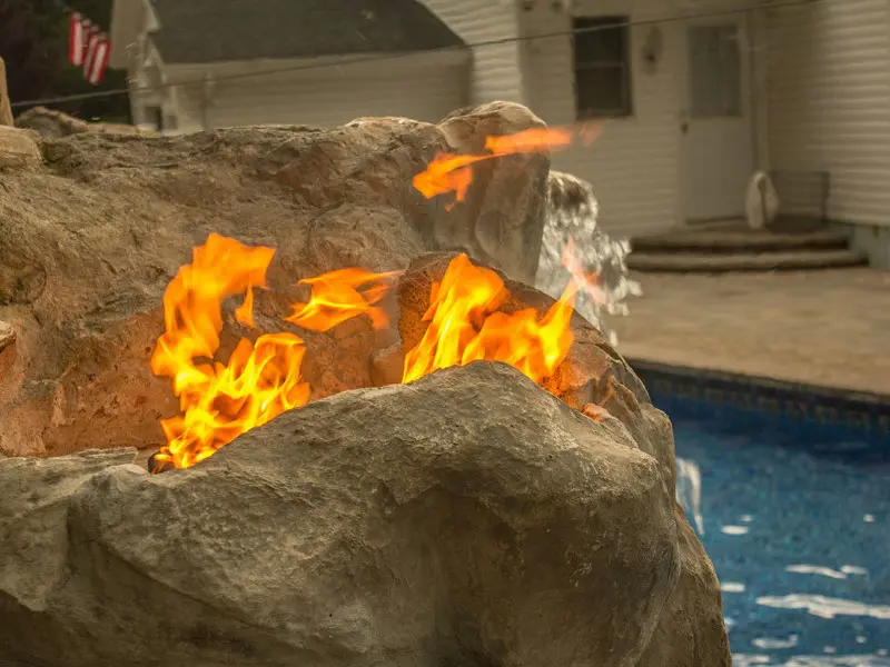 A fire burning in the middle of an outdoor pool.