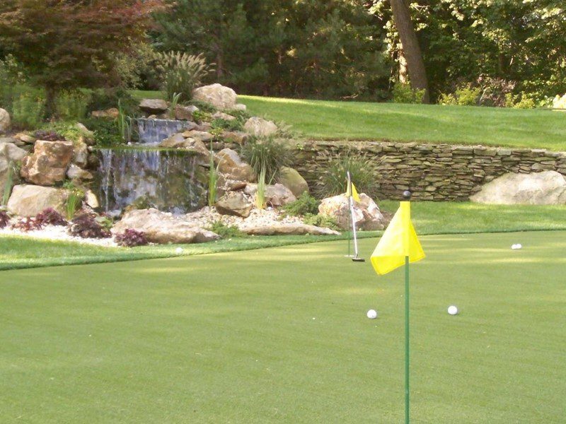 A golf course with a yellow flag and some water