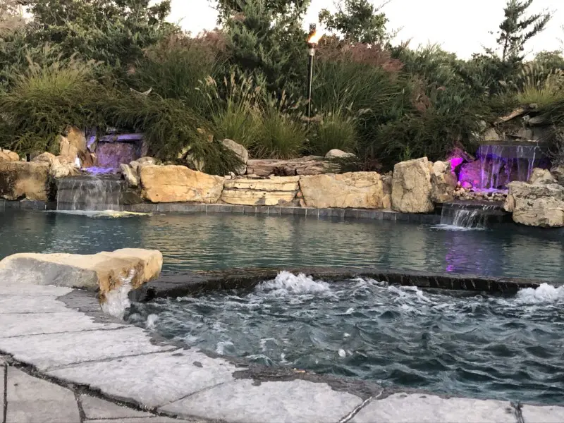 A pool with rocks and water jets in it