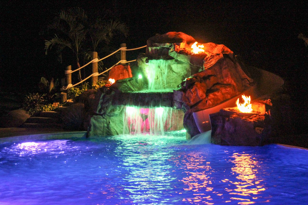 A pool with lights and water flowing over it