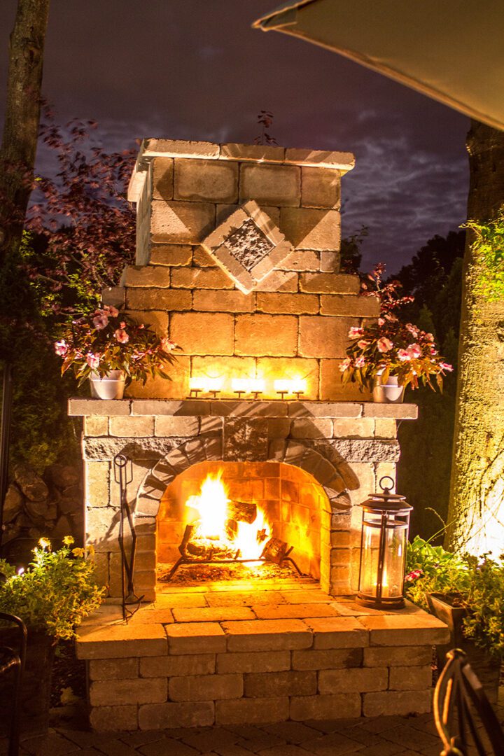 A fire place with flowers and lights in the background.