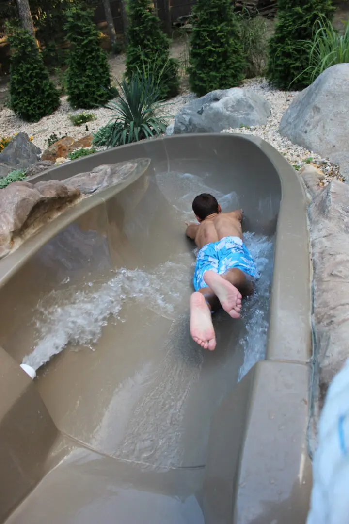 A child is riding down the water slide.