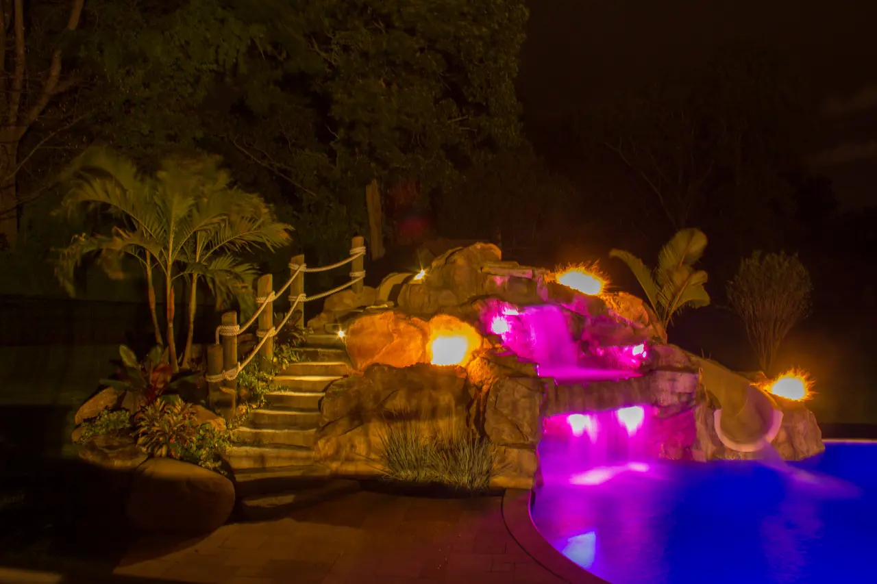 A pool with lights on it and stairs leading to the bottom.