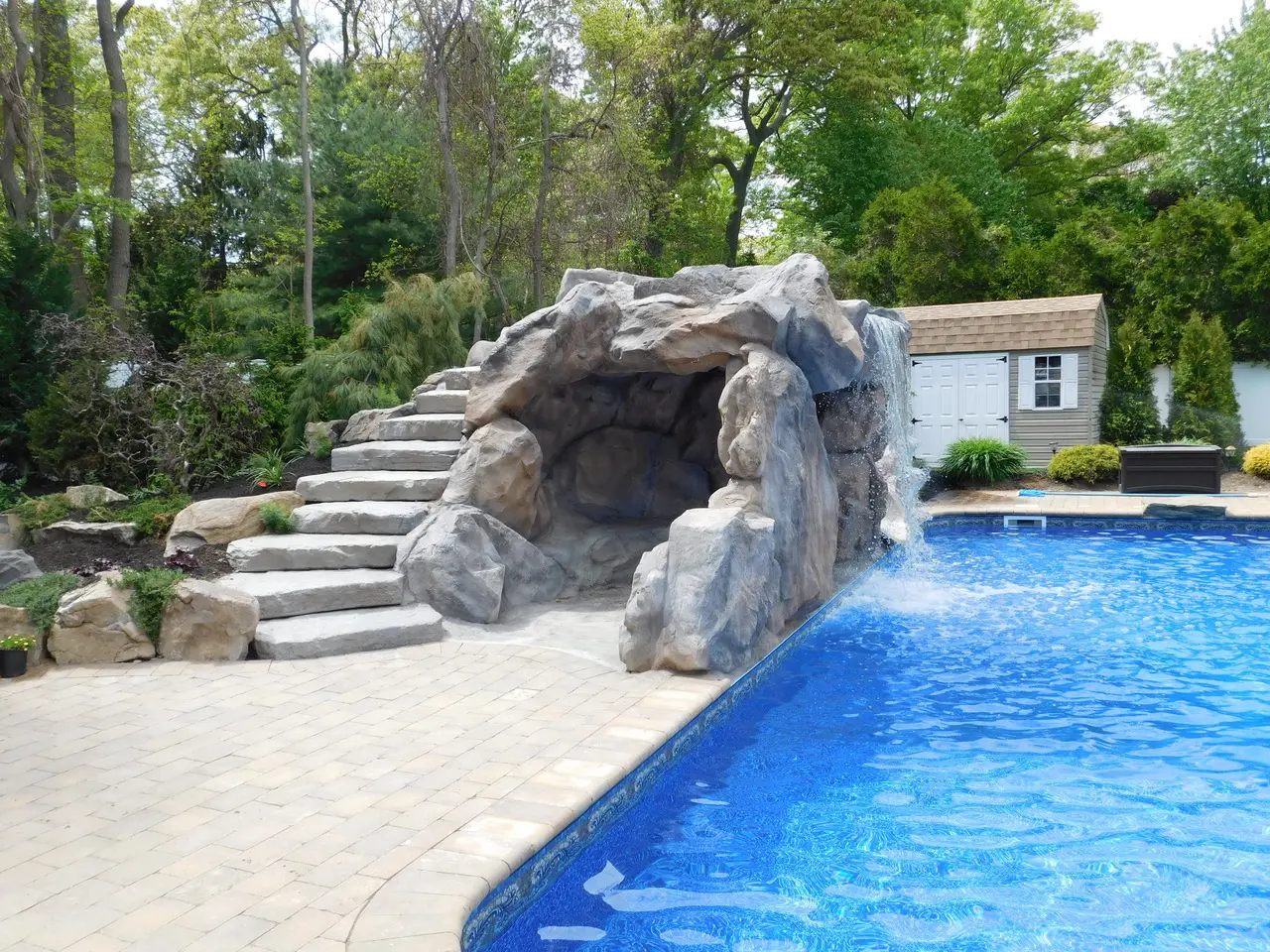 A pool with stairs and rocks in the middle of it