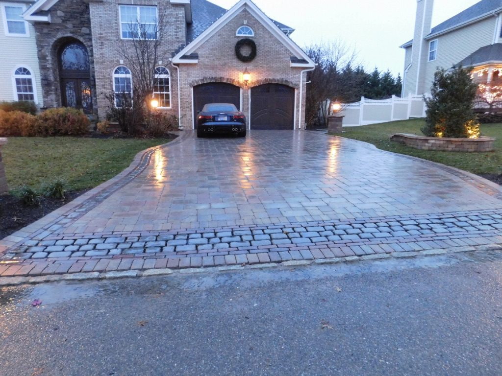 A driveway with a car parked in it.