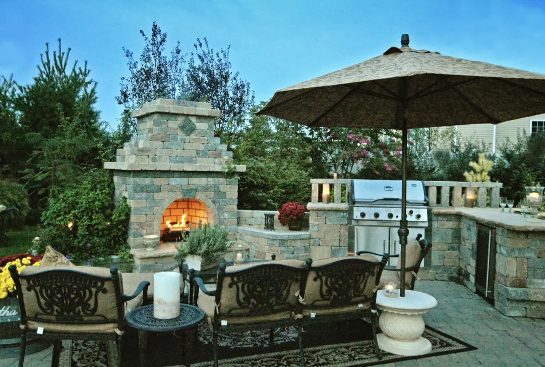 A patio with an outdoor fireplace and seating area.