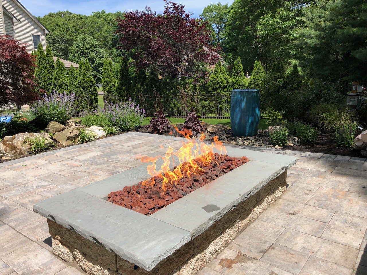 A fire pit sitting on top of a brick patio.