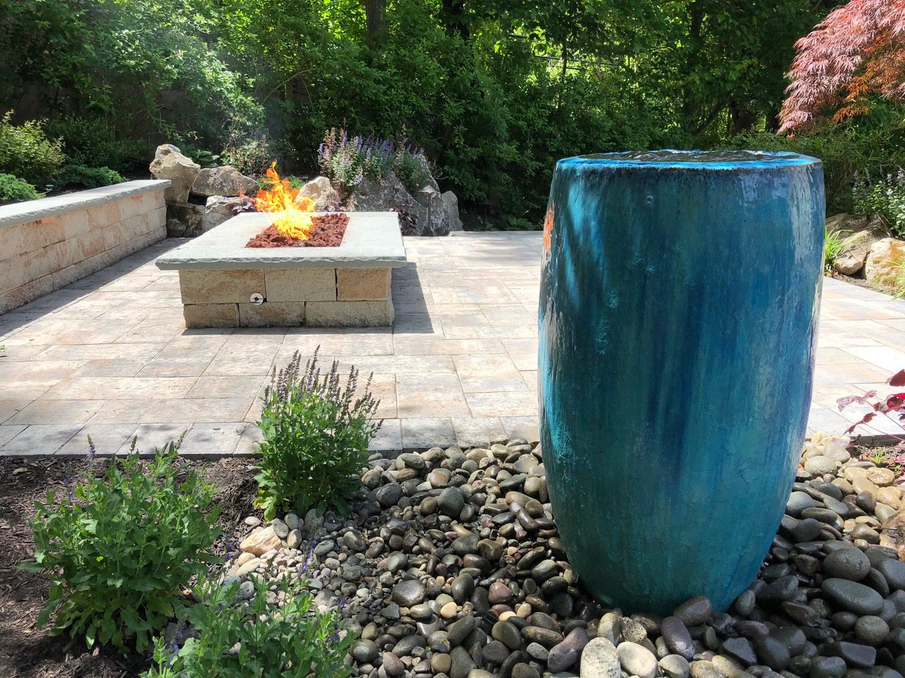 A blue vase is in the middle of a patio.