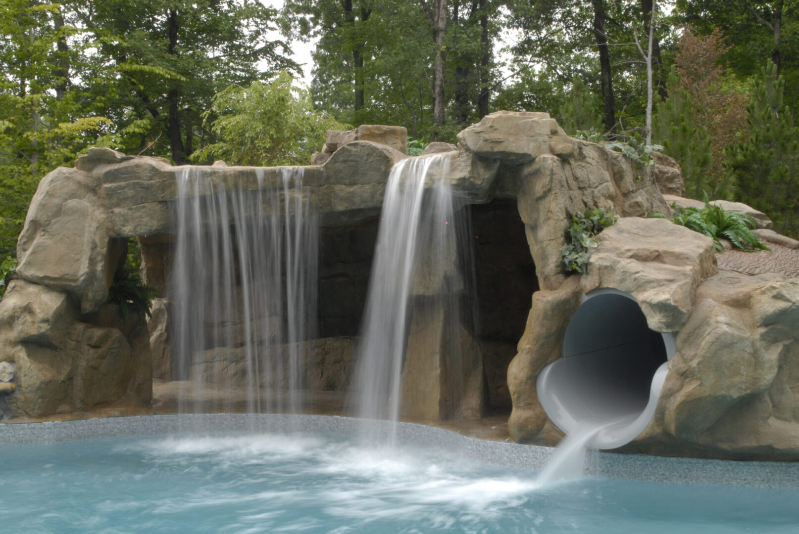 A pool with water flowing from the bottom of it.