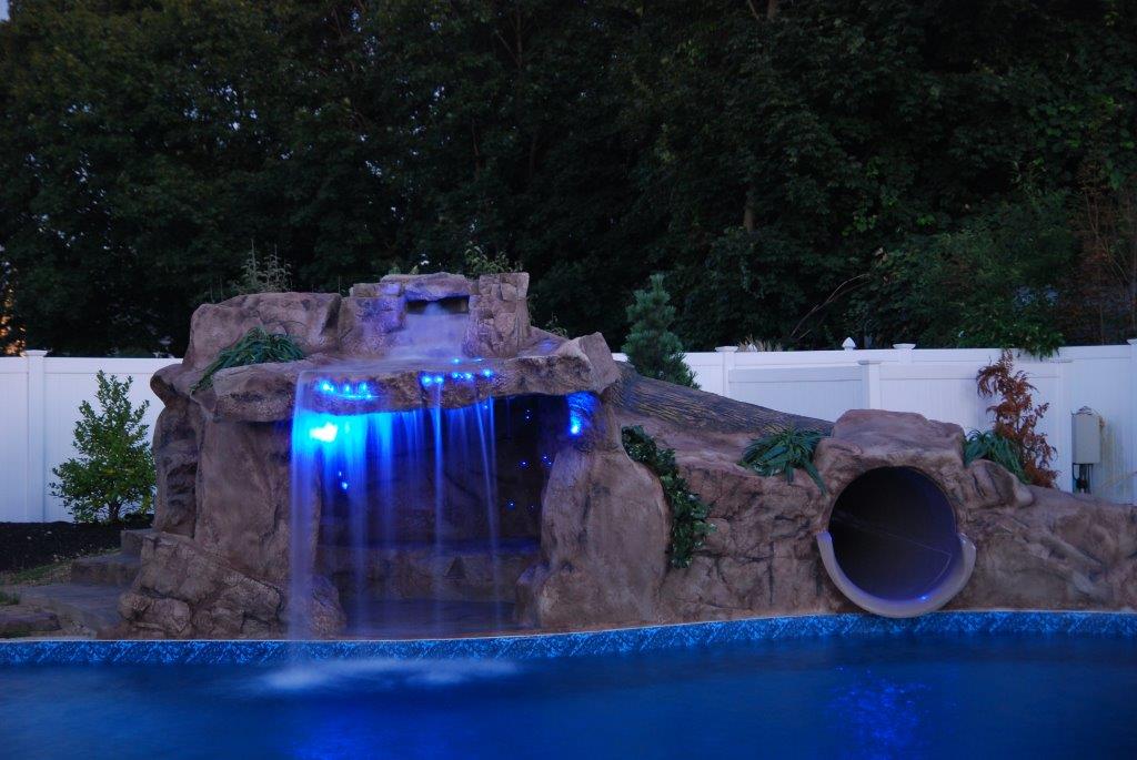 A pool with a waterfall and slide in it