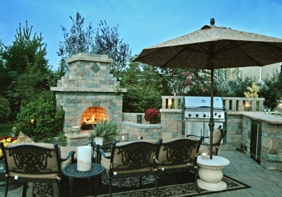 A patio with an outdoor fireplace and seating area.