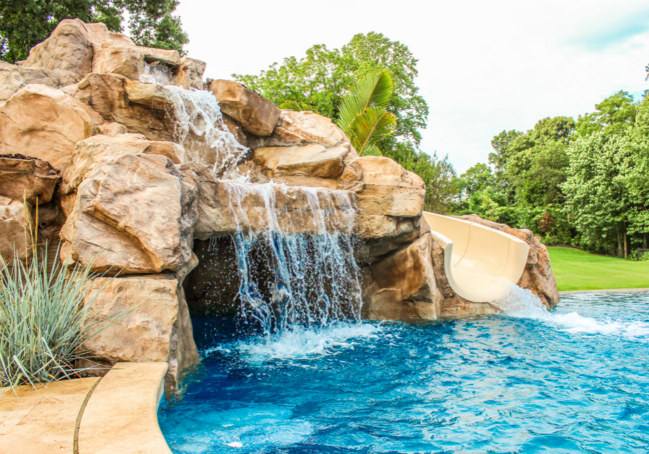 A pool with water falling down the side of it.
