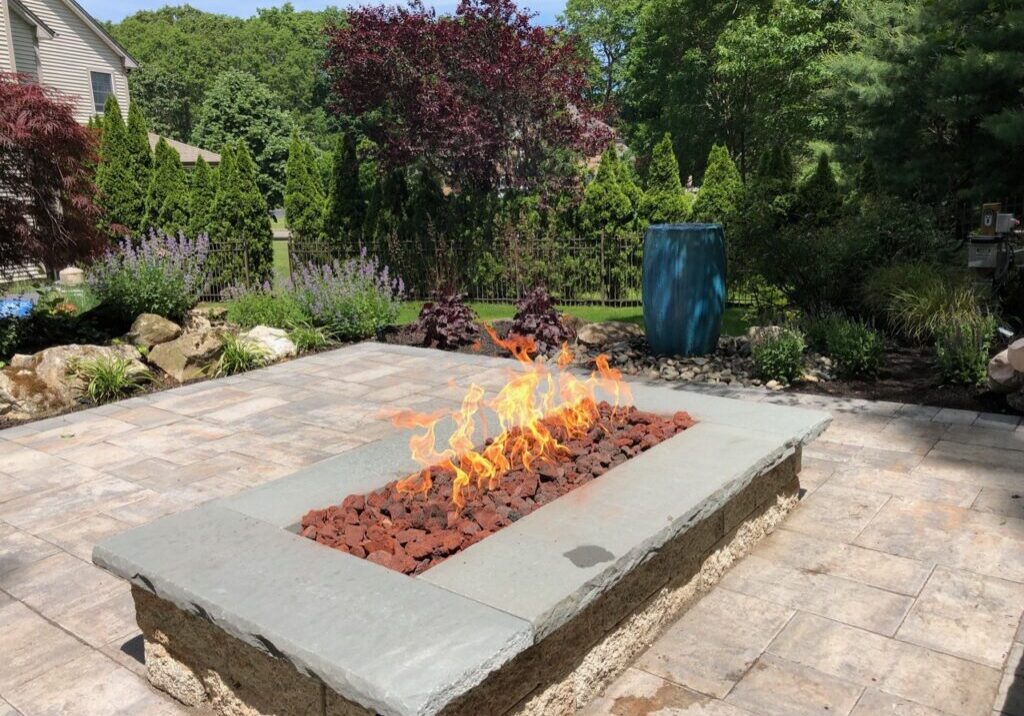 A fire pit sitting on top of a brick patio.