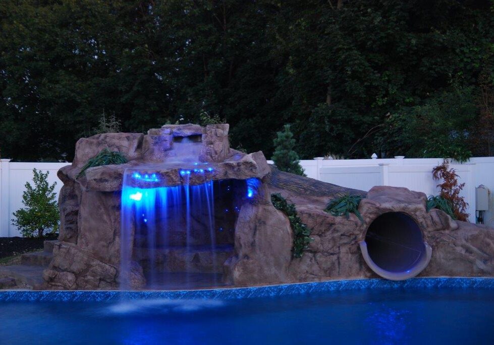 A pool with a waterfall and slide in it